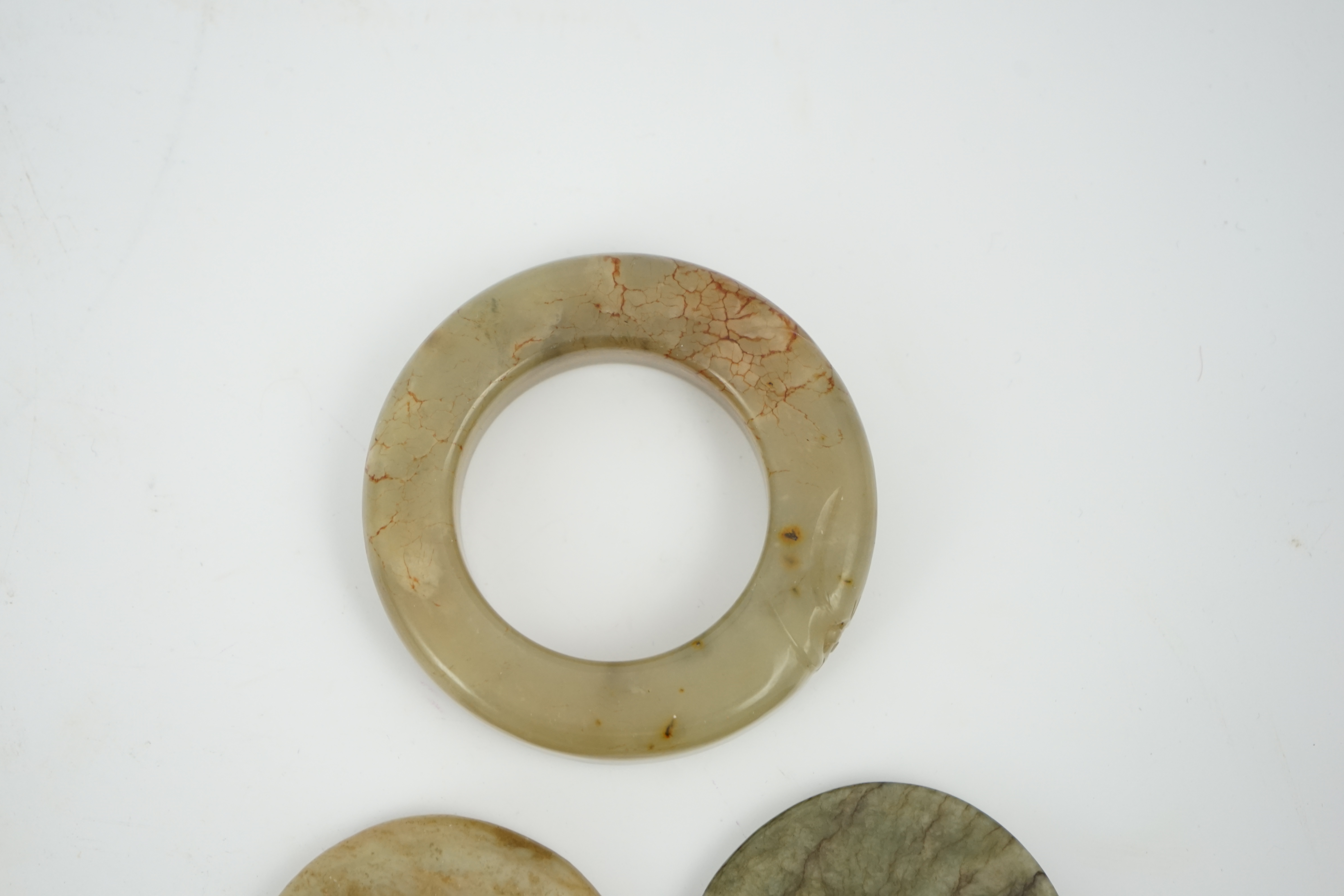 Two Chinese soapstone bi discs, and a jade ring, 18th century or earlier, largest 6.5cm in diameter. Condition - good